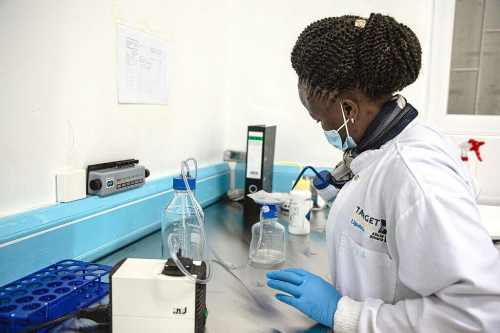 A staff member in the insectary bleaches mosquito eggs using laboratory equiptment
