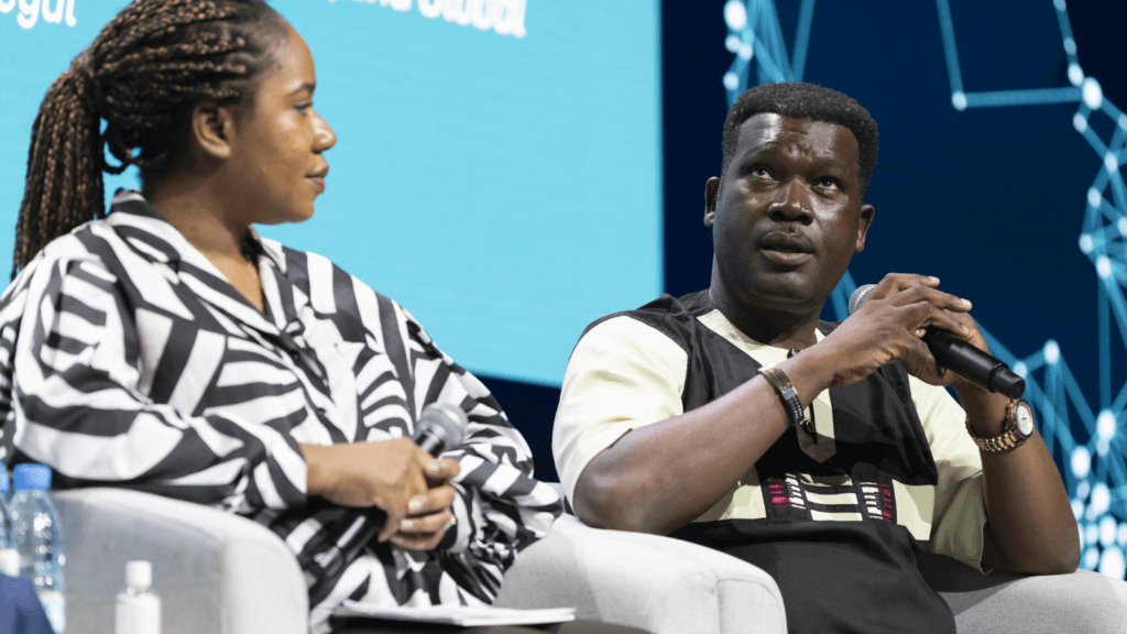 Professor Diabate on the panel at the annual Grand Challenges meeting. Another panel mamber listens as Prof. Diabate speaks into his microphone.