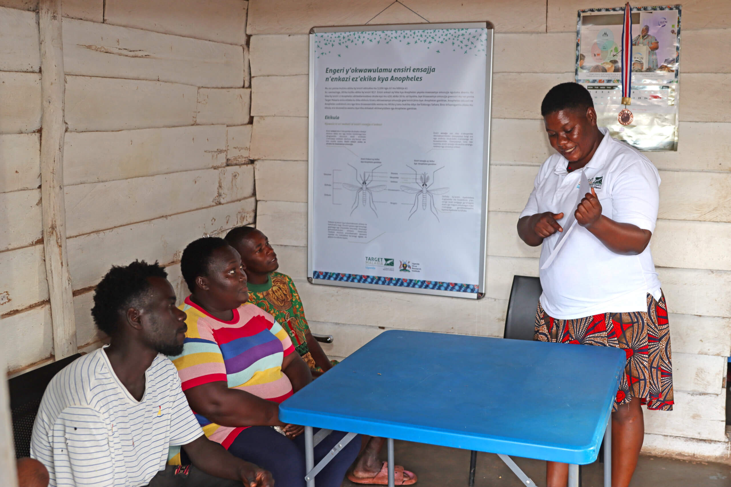 Allen explaining to stakeholders at the target malaria field office in Kansambwe about the project work.